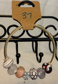 Gold toned wrap bracelet with clover charm