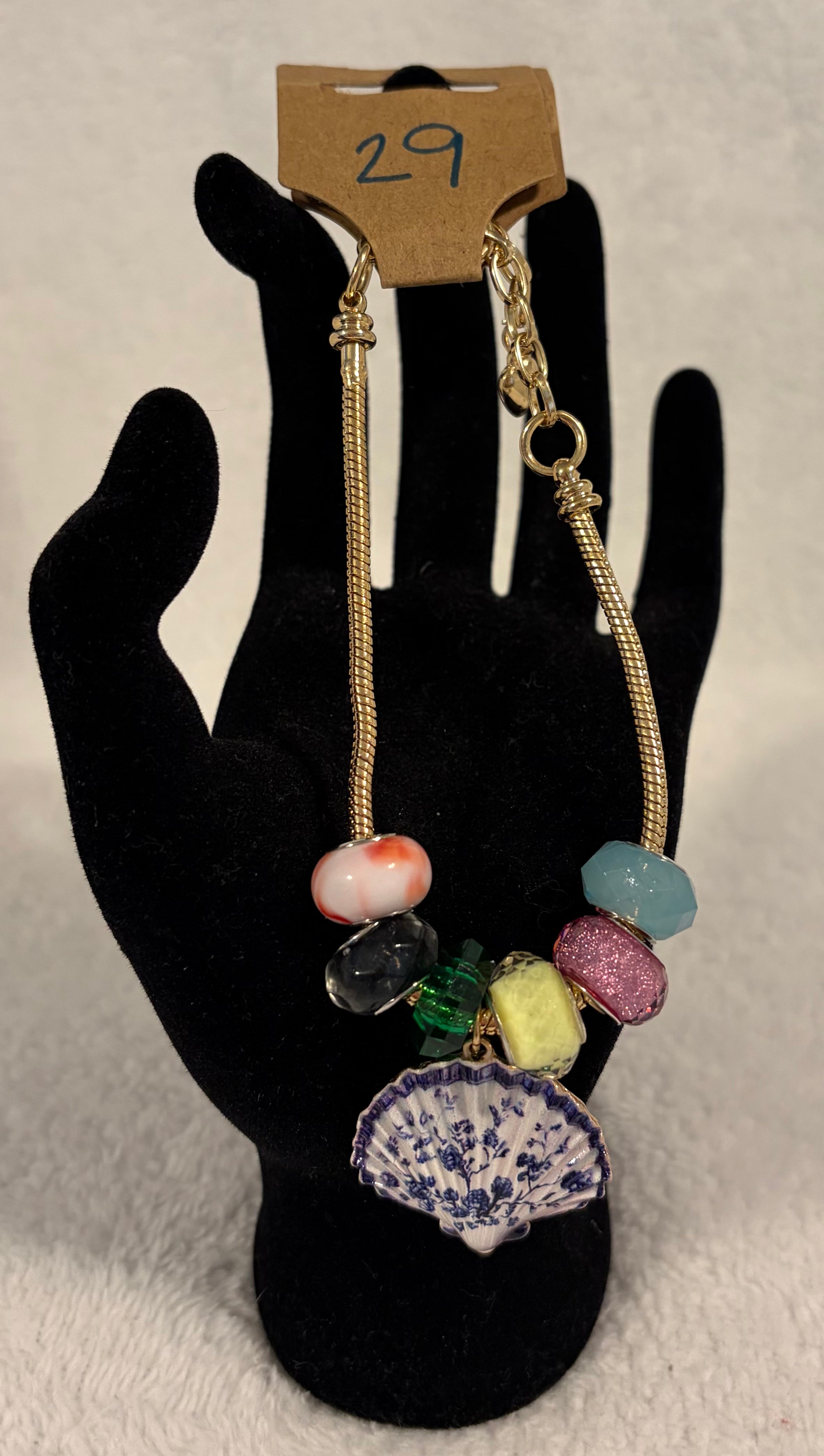 Gold toned adjustable bracelet with shell charm