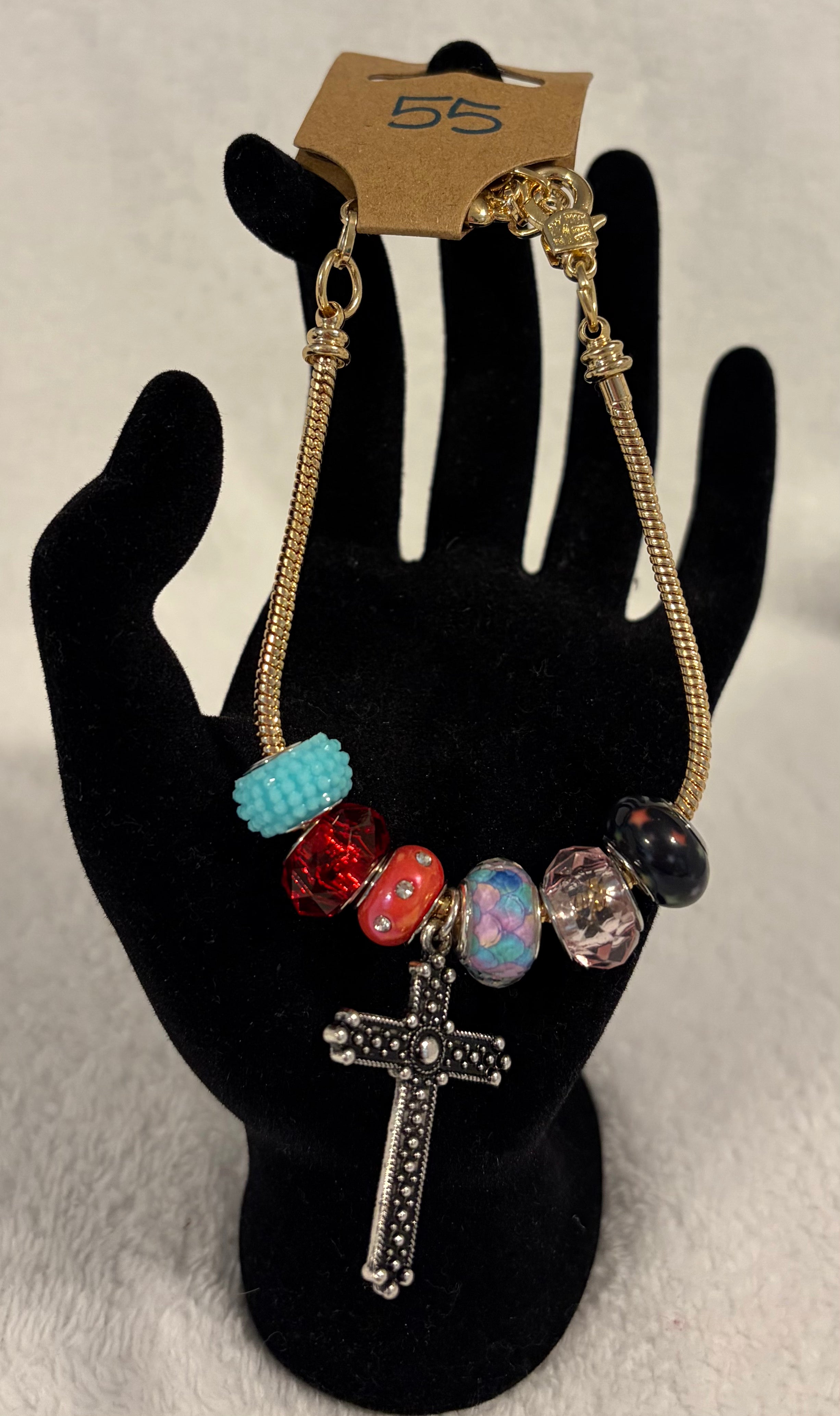 Gold toned adjustable bracelet with cross charm